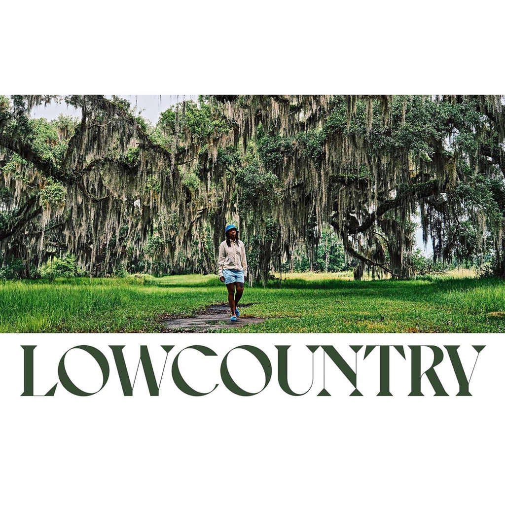 A person strolls along a path enveloped by lush greenery and moss-draped trees, capturing the essence of Southern cuisine and regional traditions. The word "Our South: Black Food Through My Lens" by Gneiss Spice is prominently displayed at the bottom of the image.