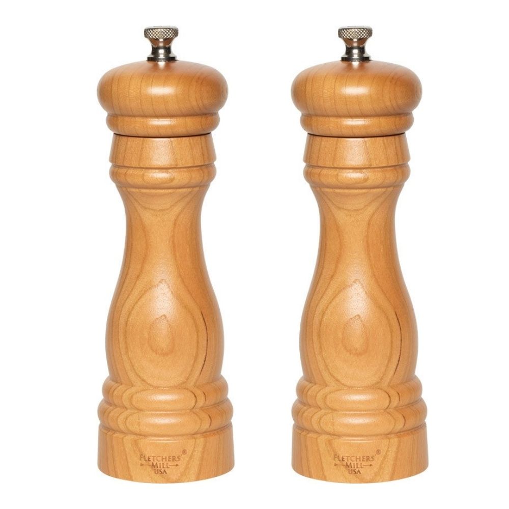 Two wooden pepper mills from the Gneiss Spice Grinder Gift Set, created with sustainably-harvested wood, stand side by side against a plain white background. They showcase a classic design with metal knobs on top and offer adjustable coarseness for precise seasoning control. This bundle includes refills and a funnel for added convenience.