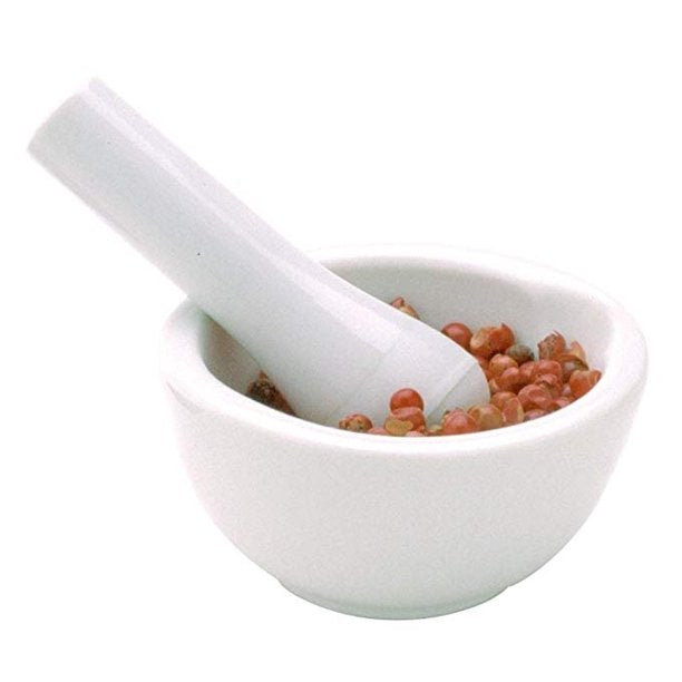 Crafted by Gneiss Spice, the elegant Mortar & Pestle — Medium 3.5" in sleek white porcelain is perfect for grinding spices, cradling small pinkish-red seeds with ease.