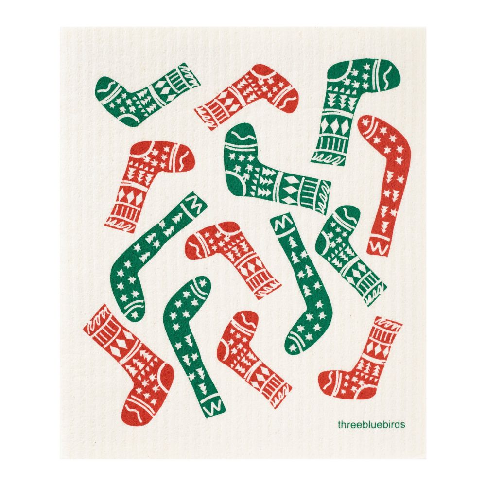 Patterned socks in red and green are scattered across a white background, boasting festive designs like stars, stripes, and snowflakes. These socks are as eco-friendly as the Swedish Dishcloth Holiday Promotion by Gneiss Spice — Buy 3, Get 1 Free.