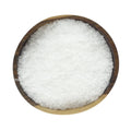 Coarse white kosher sea salt flakes in a round wooden bowl