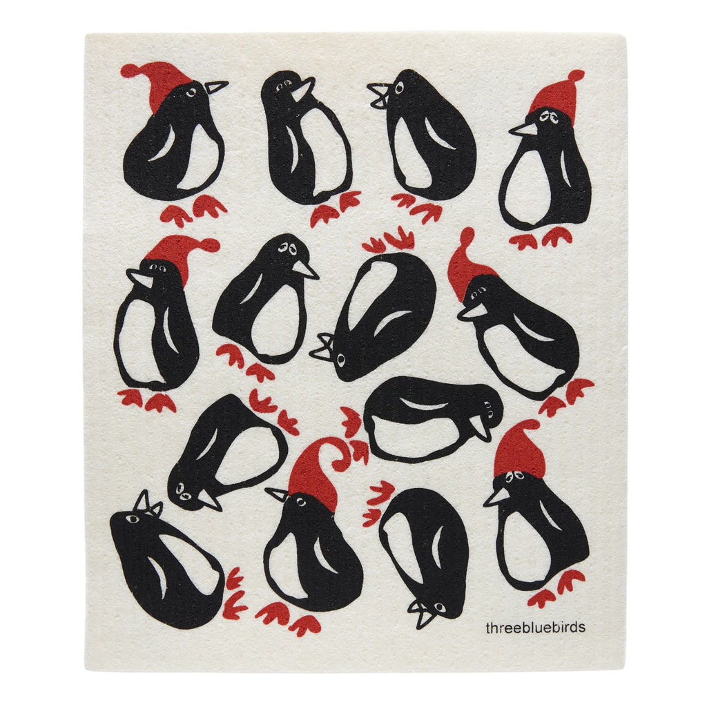 The Gneiss Spice Swedish Dishcloth — Penguins features a charming design of cartoon penguins in red Santa hats, playfully arranged on a white background, providing an eco-friendly and sustainable solution for your kitchen cleanup needs.