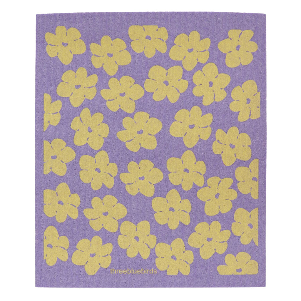 A Swedish Dishcloth from Gneiss Spice features a purple rectangular eco-friendly cloth embellished with a pattern of yellow poppies scattered across it. The stylized, evenly spaced floral design enhances its charm. In the lower center, "Gneiss Spice" is elegantly displayed, representing a sustainable cleaning solution with style.