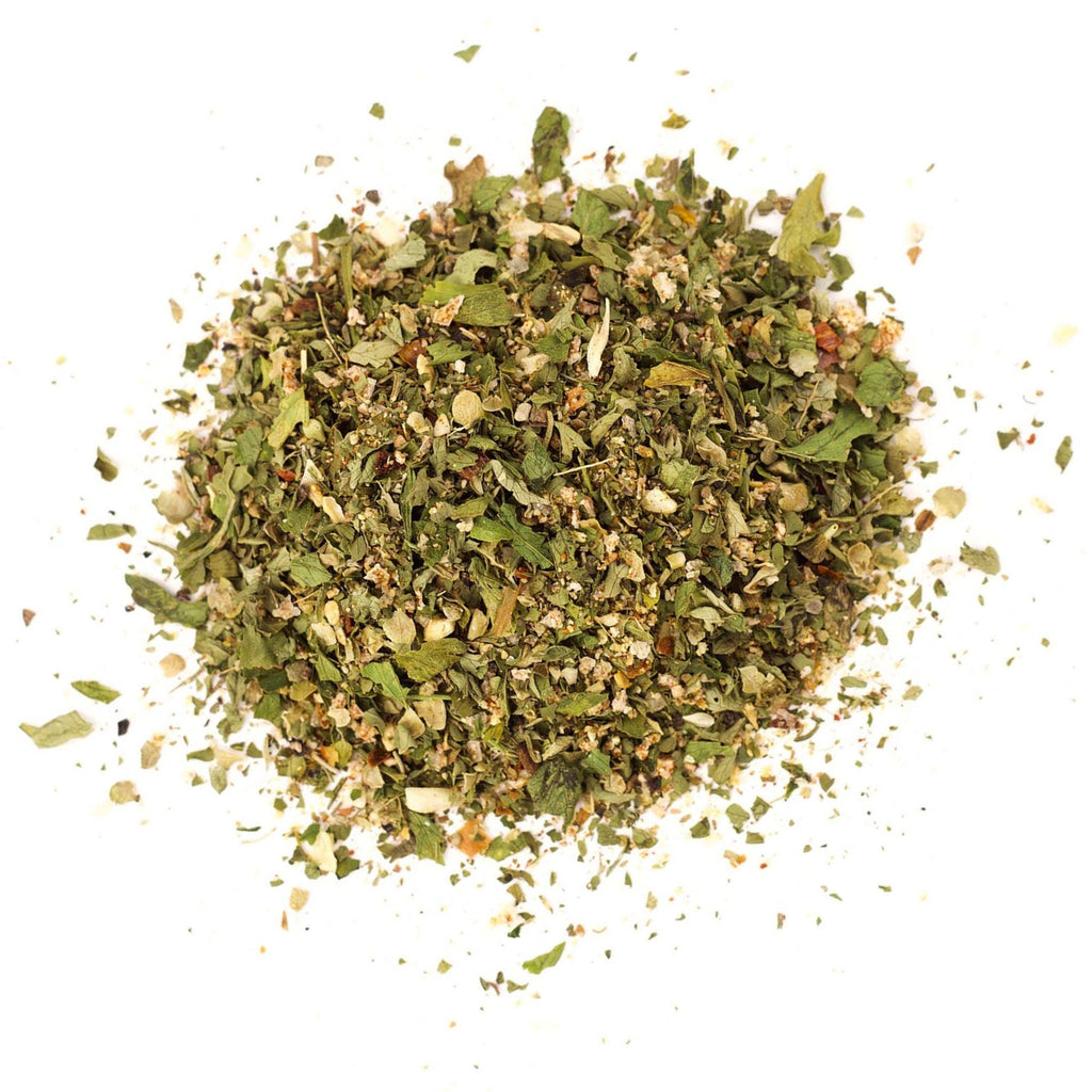 An organic blend of dried herbs and spices from Gneiss Spice forms their Vinaigrette Dressing Mix. This finely chopped mixture features green leafy herbs and small bits of orange and brown spices, ideal for creating a perfect vinaigrette mix against a plain white background.