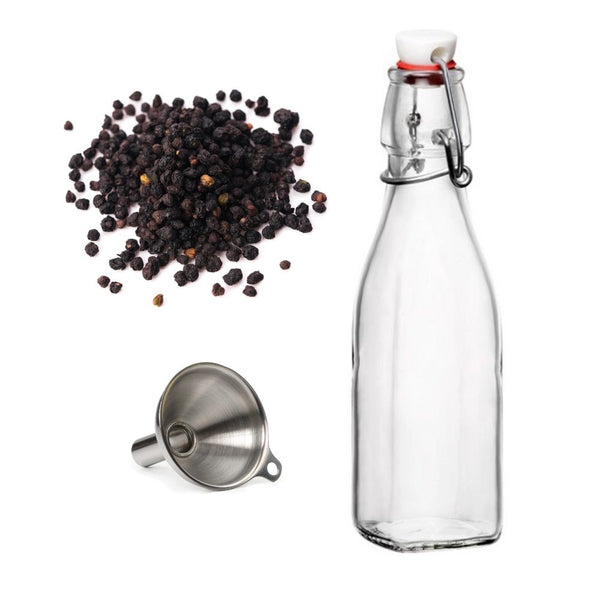 A glass flip-top bottle stands upright next to a small metal funnel and a pile of black peppercorns on a white background, mimicking the Gneiss Spice Elderberry Syrup DIY Kit—ideal for making homemade elderberry syrup as an immune booster.