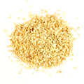 Gneiss Spice Garlic (Minced) — USA Grown features small, light yellow granules scattered on a white background. The finely chopped texture looks like dried minced garlic, perfect as a zero-waste spice for eco-friendly kitchens.